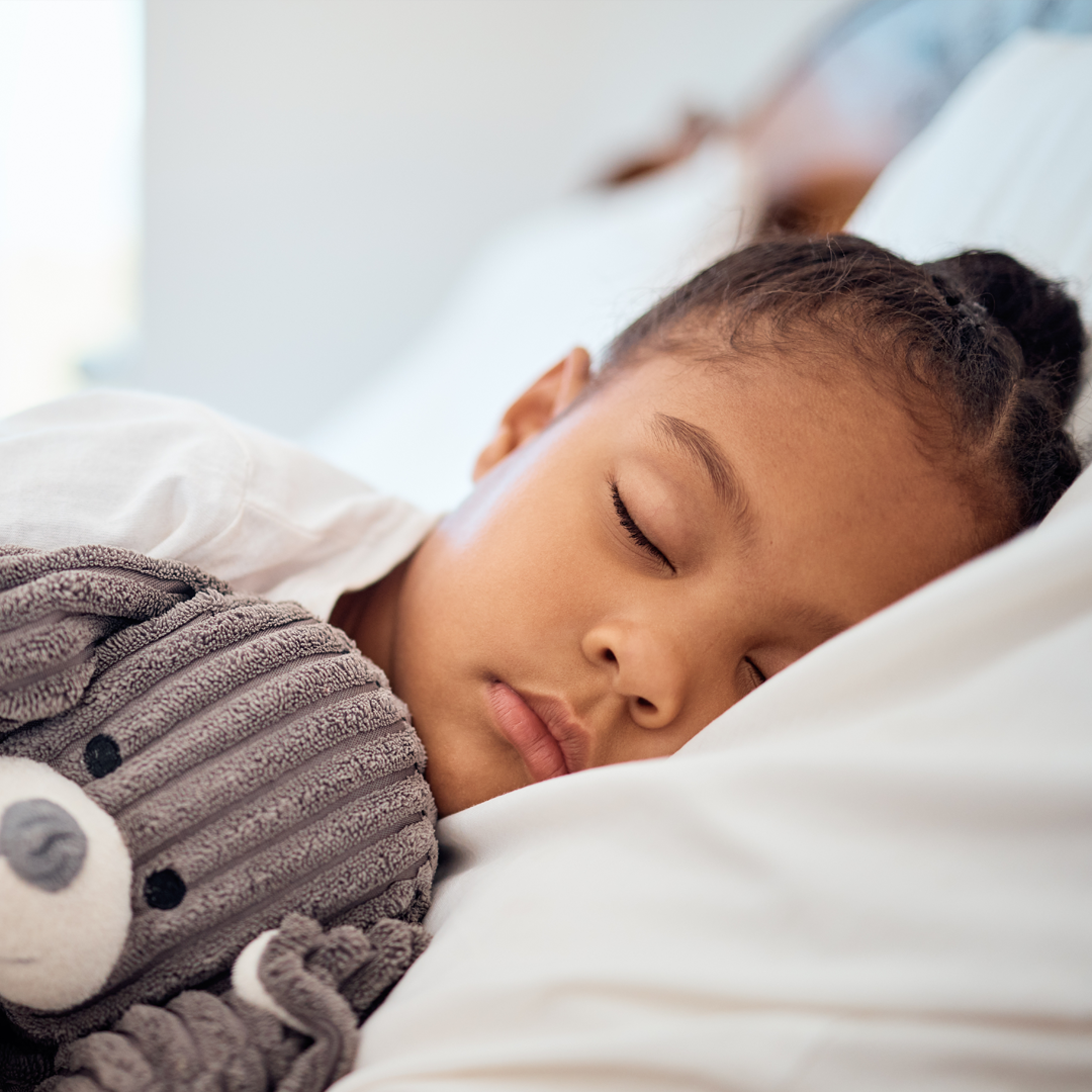 Child sleeping peacefully while holding a stuffed animal