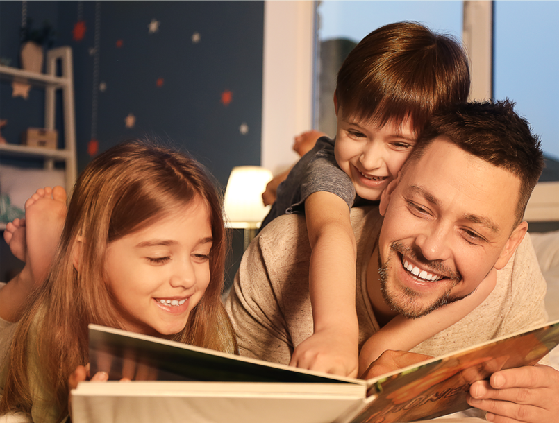 Parent reading with two children at bedtime