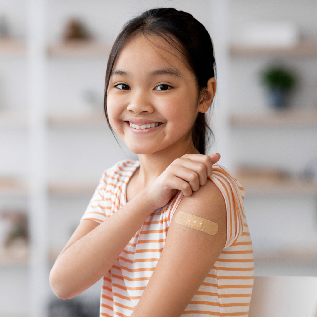 Smiling child with a bandage after receiving a vaccine